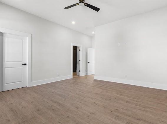 spare room featuring baseboards, a ceiling fan, wood finished floors, and recessed lighting