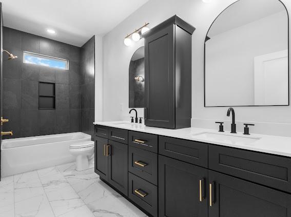 full bath with double vanity, marble finish floor, shower / tub combination, and a sink