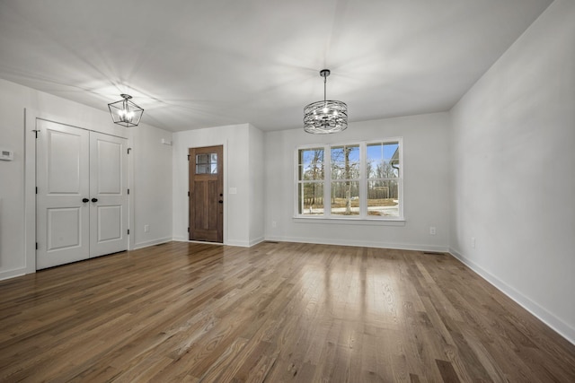 foyer with dark wood-type flooring and an inviting chandelier