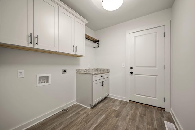 washroom featuring dark wood-type flooring, cabinets, washer hookup, and electric dryer hookup