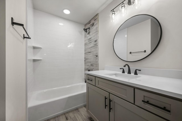 bathroom featuring tiled shower / bath combo, wood-type flooring, and vanity