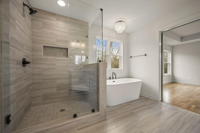 bathroom with independent shower and bath, hardwood / wood-style flooring, and a wealth of natural light