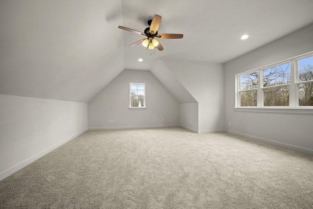 bonus room with vaulted ceiling, light carpet, and ceiling fan