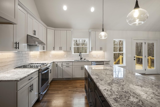 kitchen with white cabinetry, appliances with stainless steel finishes, sink, and decorative light fixtures