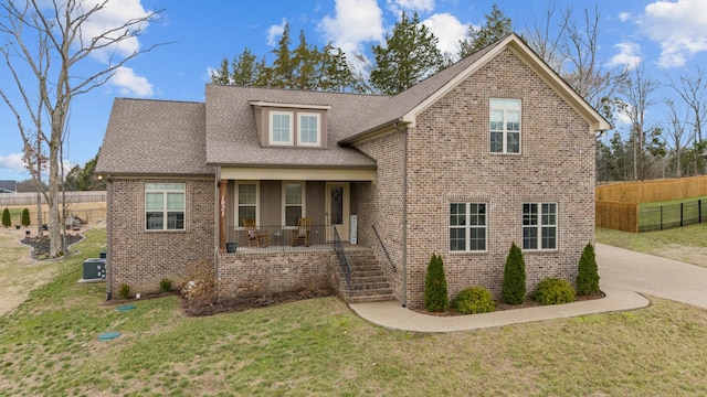 view of front of property featuring a porch, central AC unit, and a front lawn