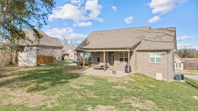 rear view of house featuring a patio, a yard, and central AC