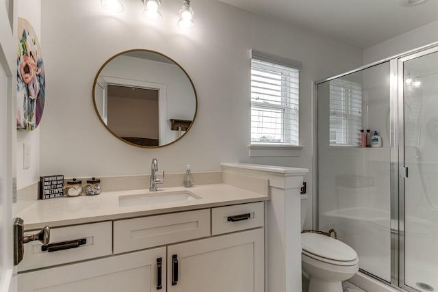 bathroom with toilet, vanity, and walk in shower