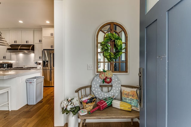 kitchen with tasteful backsplash, stainless steel refrigerator with ice dispenser, hardwood / wood-style flooring, and white cabinets