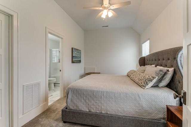 carpeted bedroom with ceiling fan, ensuite bath, and vaulted ceiling