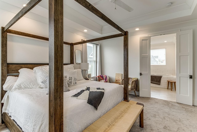 bedroom featuring multiple windows, carpet flooring, ensuite bath, and beamed ceiling