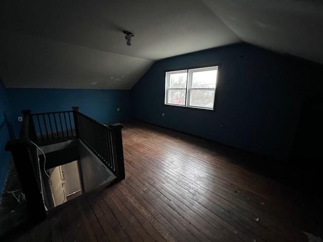 bonus room with dark wood-type flooring and vaulted ceiling