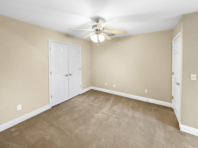 unfurnished bedroom featuring light carpet, a closet, and ceiling fan