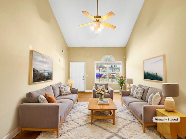 living room featuring ceiling fan, high vaulted ceiling, and light wood-type flooring