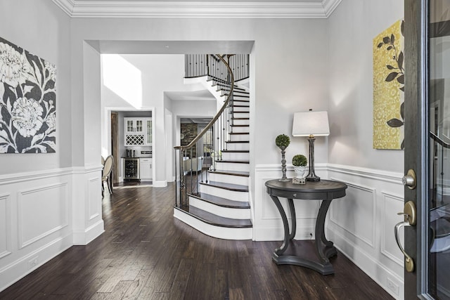 foyer entrance with bar area, crown molding, wine cooler, and hardwood / wood-style flooring