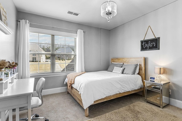 carpeted bedroom with a notable chandelier