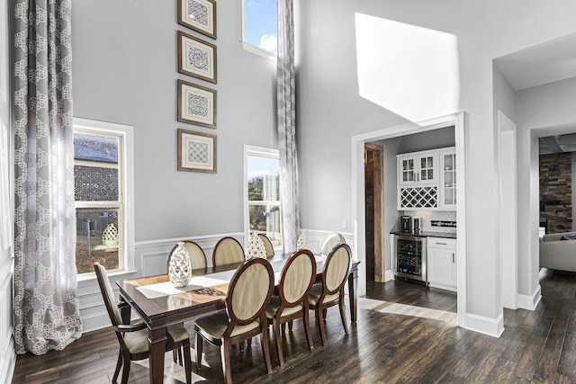 dining area with indoor bar, dark wood-type flooring, and beverage cooler