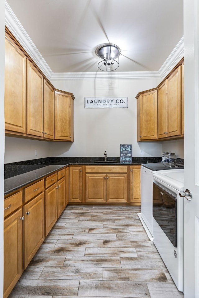 kitchen featuring separate washer and dryer, sink, light hardwood / wood-style flooring, and ornamental molding