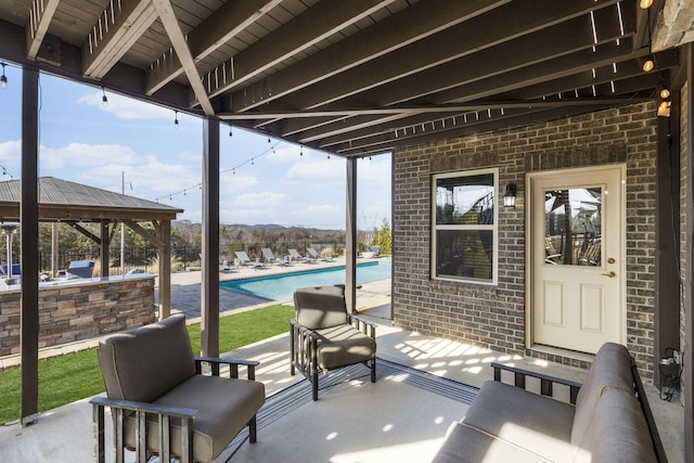 view of patio / terrace featuring a fenced in pool, a gazebo, and exterior bar