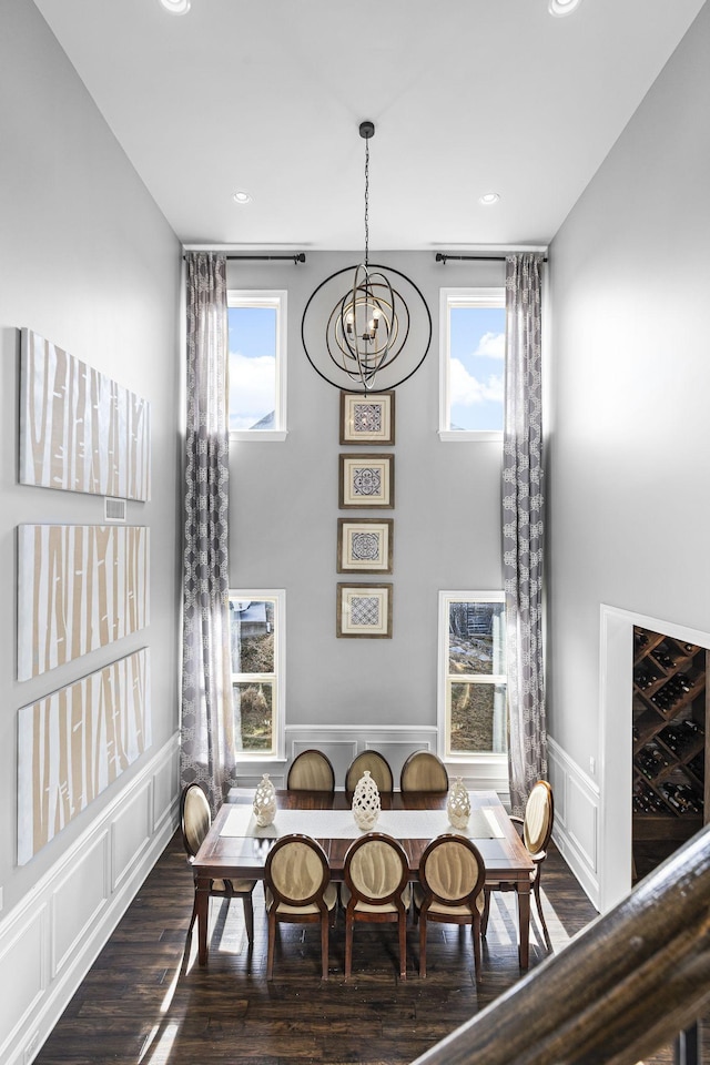 dining room featuring a notable chandelier, dark hardwood / wood-style floors, and a high ceiling