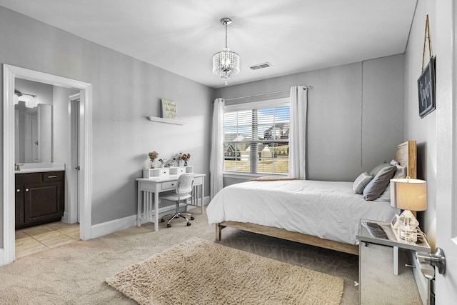 bedroom with ensuite bathroom, light carpet, and a notable chandelier