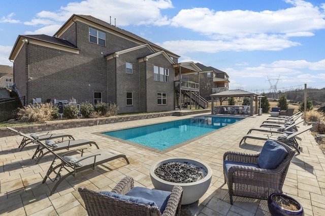 view of swimming pool with a gazebo, a patio area, and an outdoor fire pit