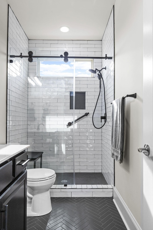 bathroom with an enclosed shower, vanity, and toilet