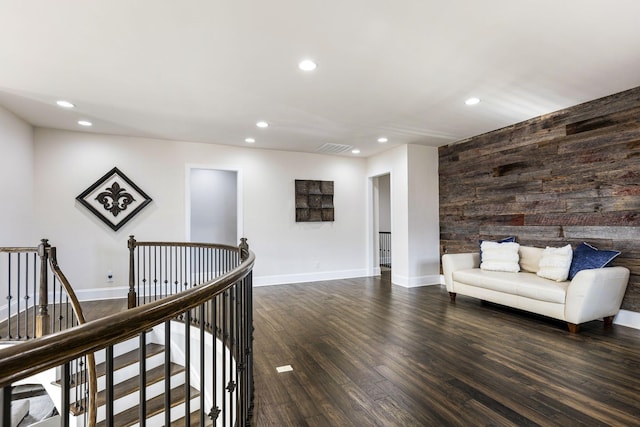 living area featuring dark hardwood / wood-style floors and wood walls