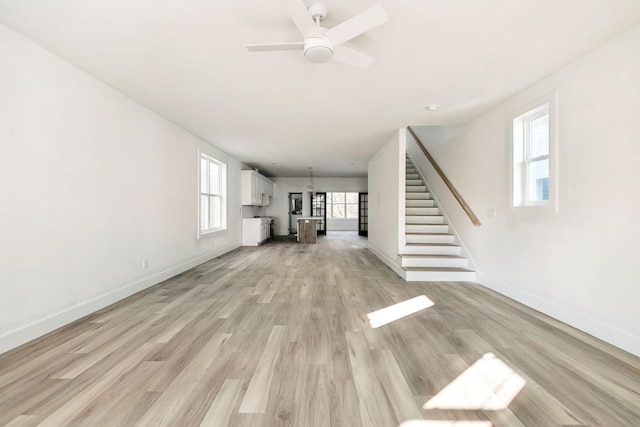 unfurnished living room with ceiling fan and light wood-type flooring