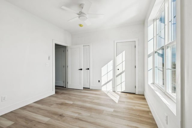 spare room with ceiling fan, a healthy amount of sunlight, and light wood-type flooring