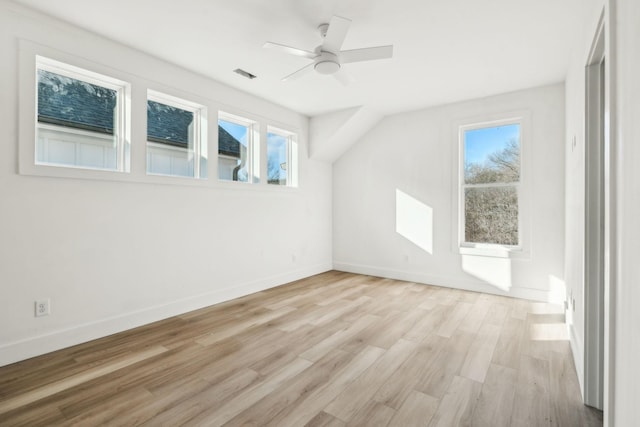 additional living space with ceiling fan, a healthy amount of sunlight, and light wood-type flooring