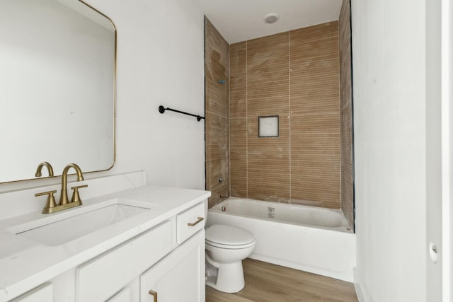 full bathroom featuring vanity, tiled shower / bath, hardwood / wood-style floors, and toilet