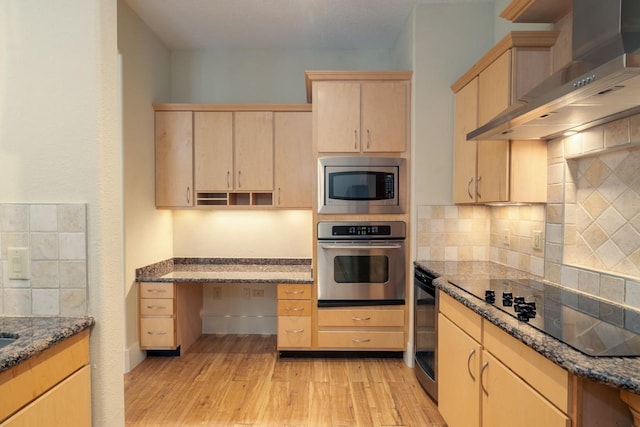 kitchen featuring stainless steel appliances, light hardwood / wood-style flooring, light brown cabinets, and wall chimney exhaust hood