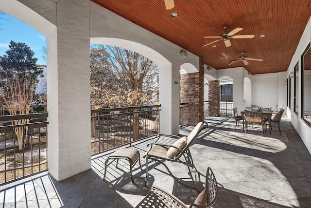 view of patio featuring ceiling fan and a balcony