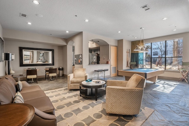 living room featuring pool table and a textured ceiling