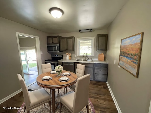 kitchen with dark wood-type flooring, appliances with stainless steel finishes, and sink