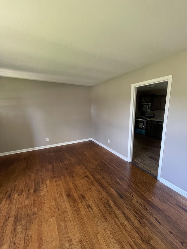 unfurnished room with dark hardwood / wood-style flooring