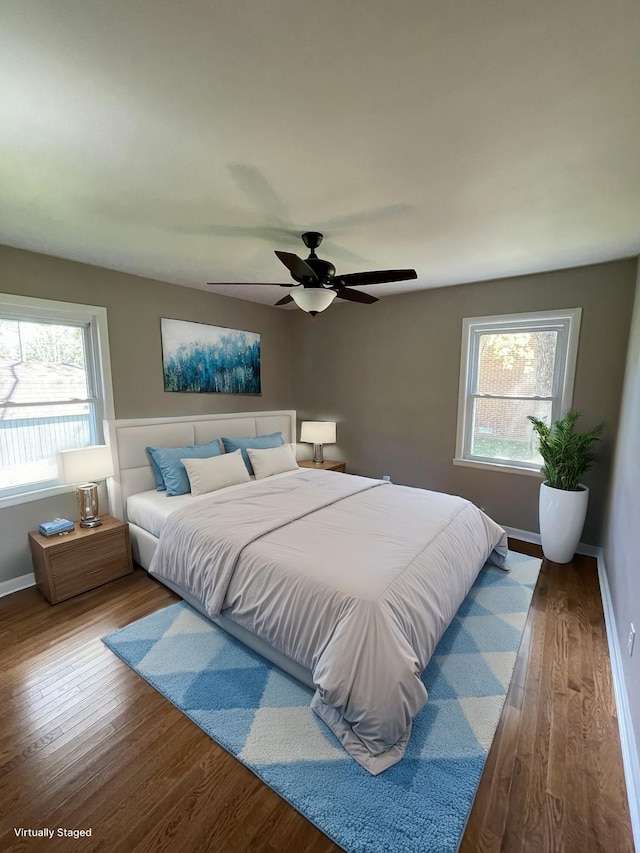 bedroom featuring hardwood / wood-style flooring, ceiling fan, and multiple windows