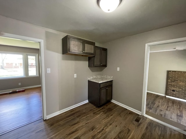 kitchen featuring dark hardwood / wood-style flooring and dark brown cabinets