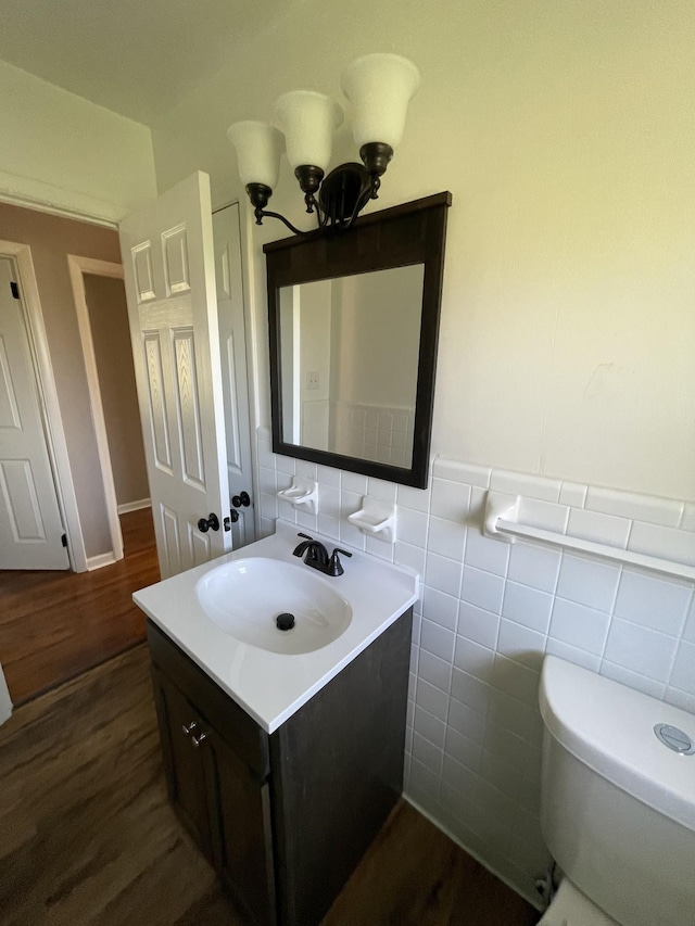 bathroom featuring hardwood / wood-style flooring, vanity, tile walls, and toilet