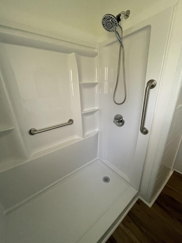 bathroom with wood-type flooring and a shower