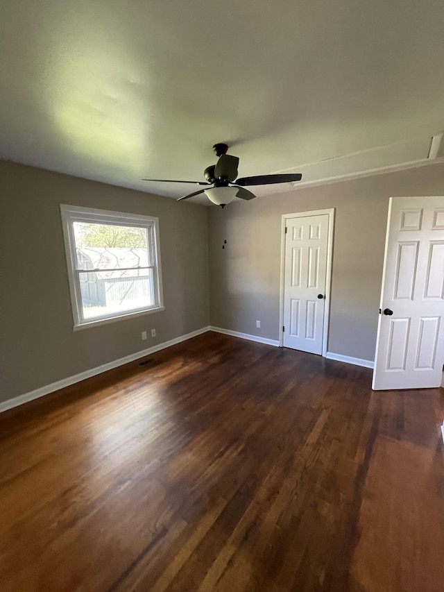 unfurnished bedroom featuring dark wood-type flooring, ceiling fan, and a closet