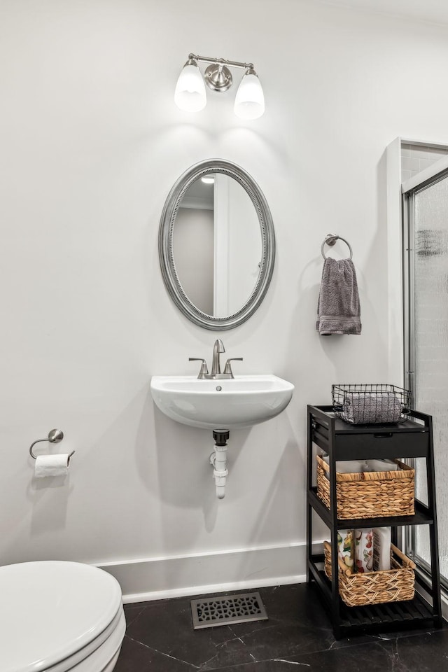 bathroom with walk in shower, toilet, tile patterned flooring, and sink