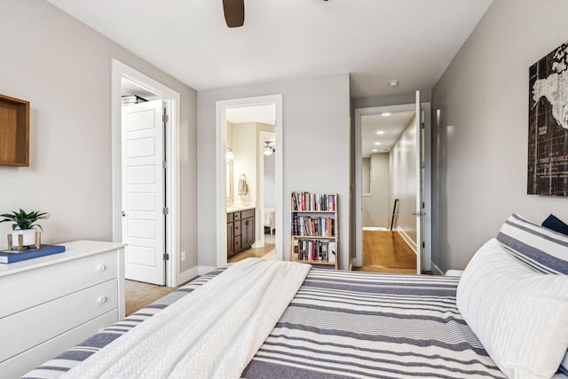 bedroom featuring light colored carpet, ceiling fan, and ensuite bathroom