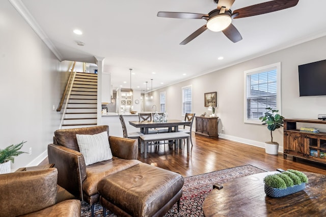 living room with hardwood / wood-style flooring, ornamental molding, and ceiling fan