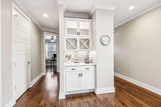 bar featuring white cabinetry, crown molding, backsplash, and dark hardwood / wood-style flooring