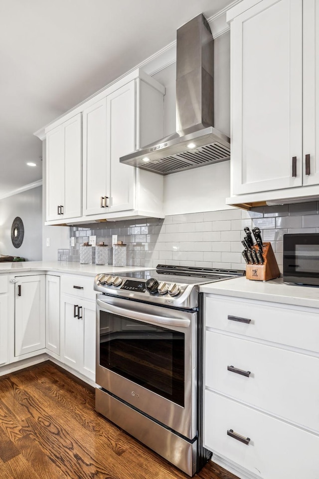 kitchen with dark wood-type flooring, white cabinetry, stainless steel electric range, decorative backsplash, and wall chimney range hood