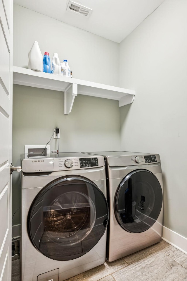 washroom featuring washer and clothes dryer and light wood-type flooring