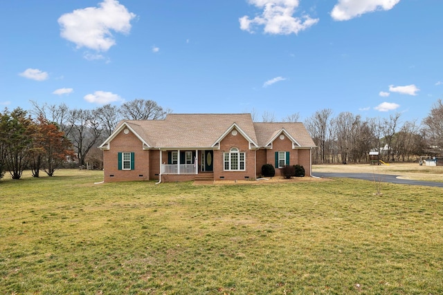 ranch-style house featuring covered porch and a front lawn