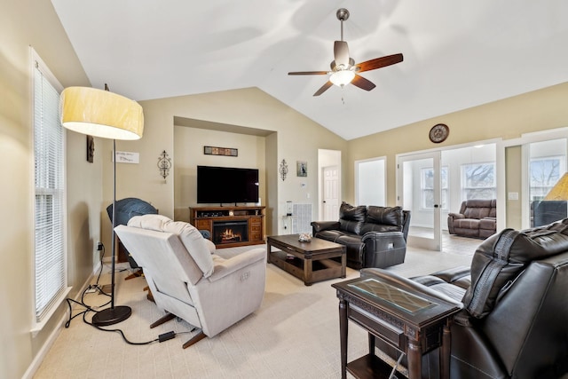 carpeted living room with french doors, ceiling fan, and vaulted ceiling