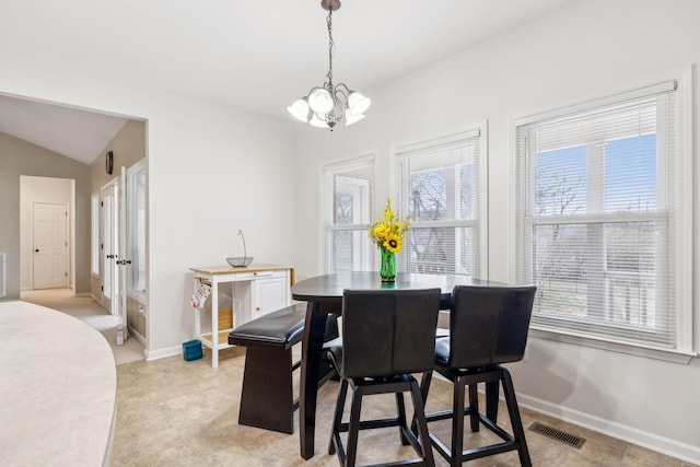 dining space with lofted ceiling and a chandelier